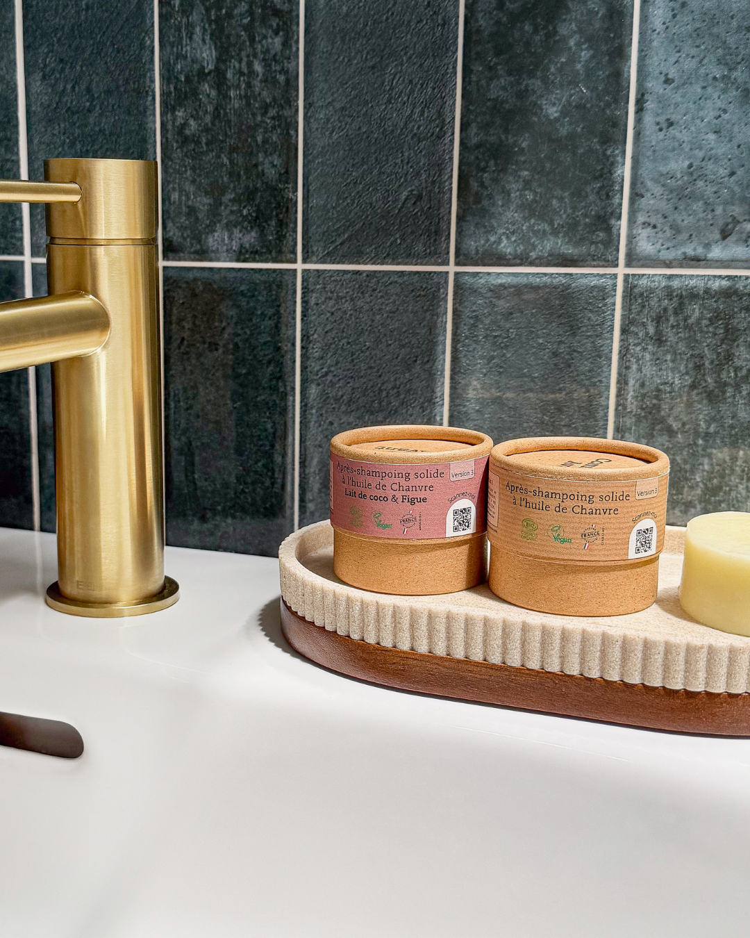 Après-shampoing solide bio Comme Avant posé sur un plateau de salle de bain